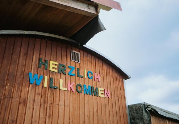 Bauwagen mit Schriftzug "Herzlich Willkommen"