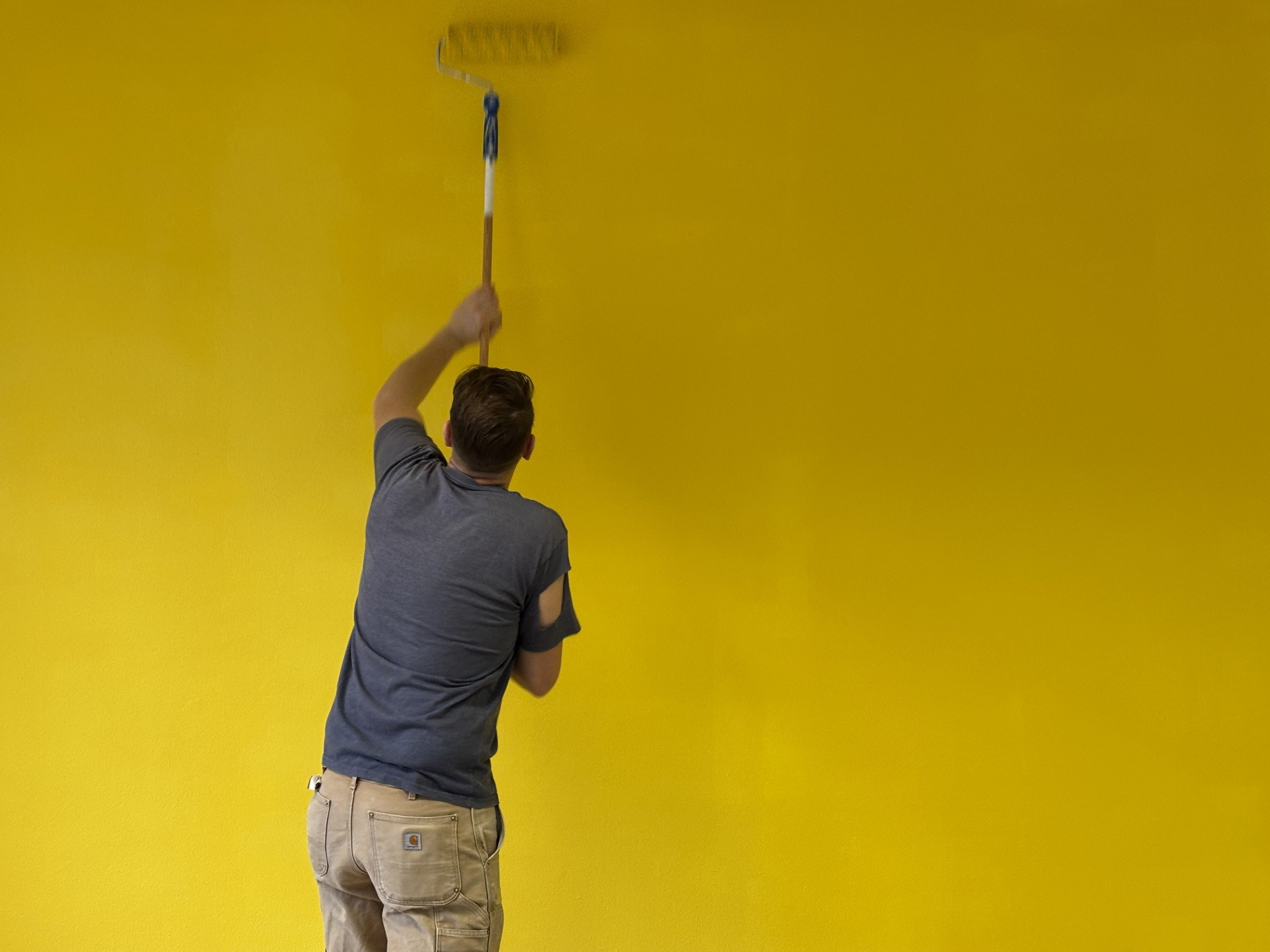 FRAMOS-Mitarbeiter streicht Wand gelb