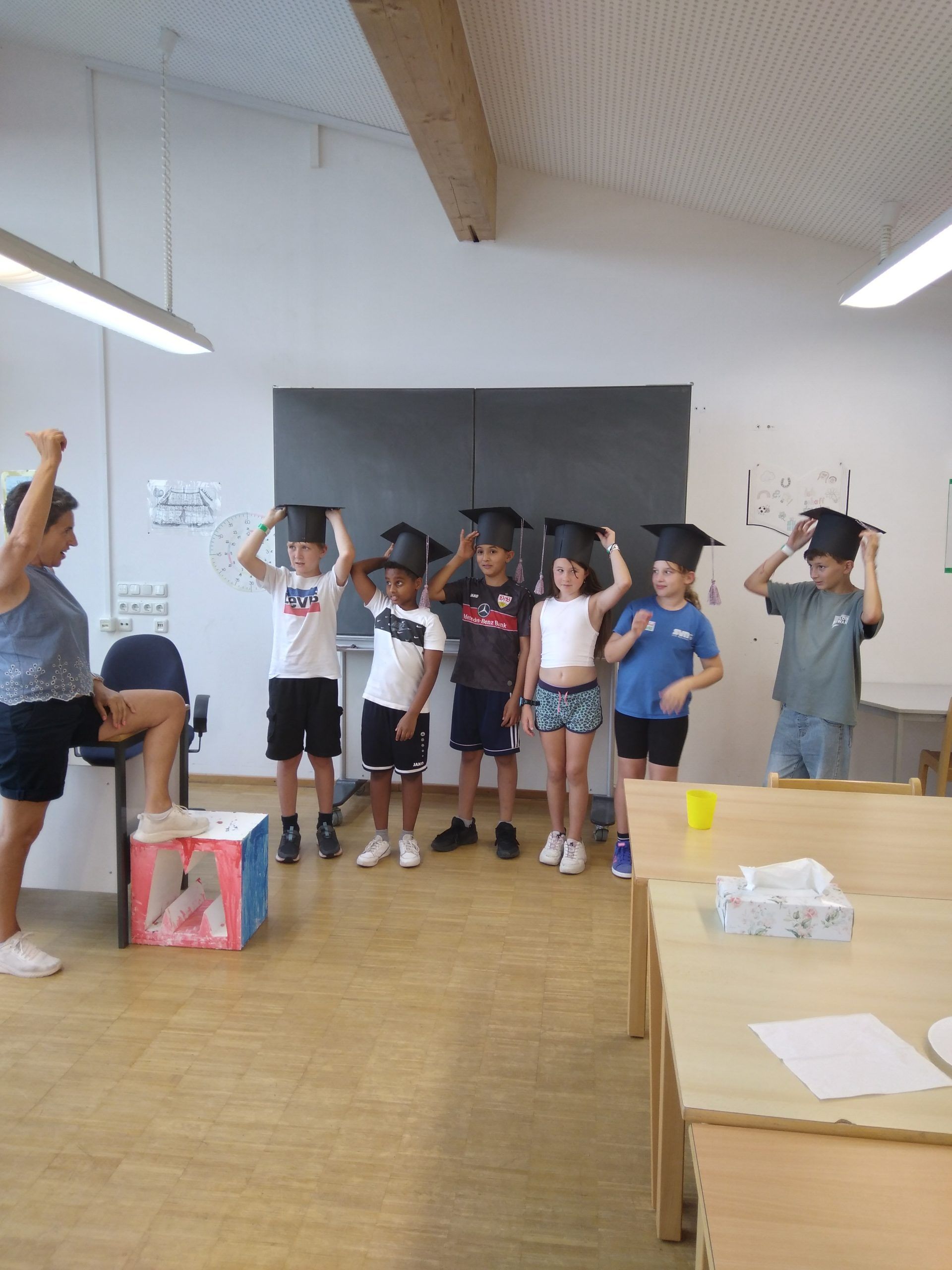 Kinder mit Studentenhut zum Abschluss