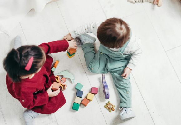 Kinder spielen mit Bauklötzen und Holztieren