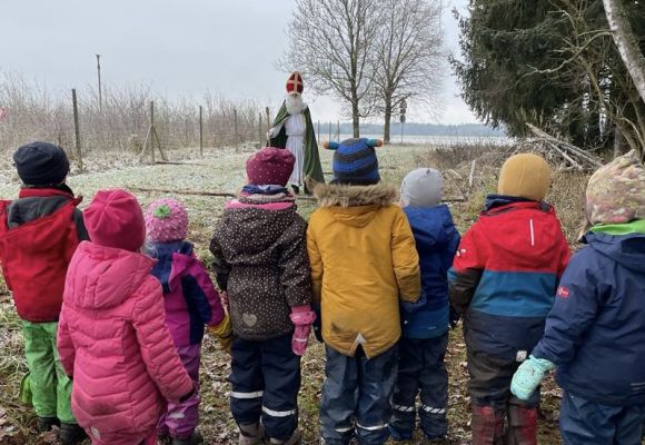 Kinder von hinten, die auf Nikolaus schauen, draußen und kalt