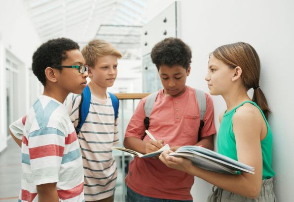 Kinder stehen zusammen mit Heften in der Hand
