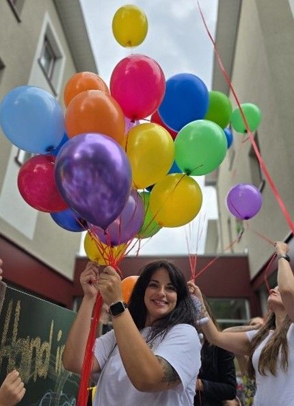 Frau hält bunte Luftballons in der Hand