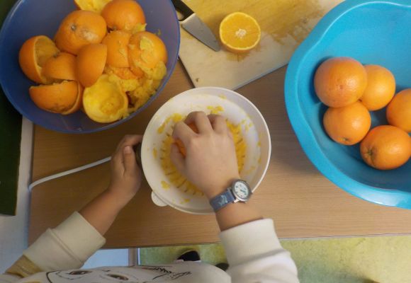 Kinderhände pressen Orangen aus