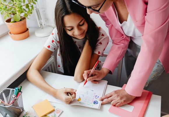 Betreuerin mit Kindern am Tisch