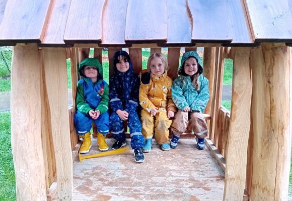 Kinder sitzen in Holzhäuschen