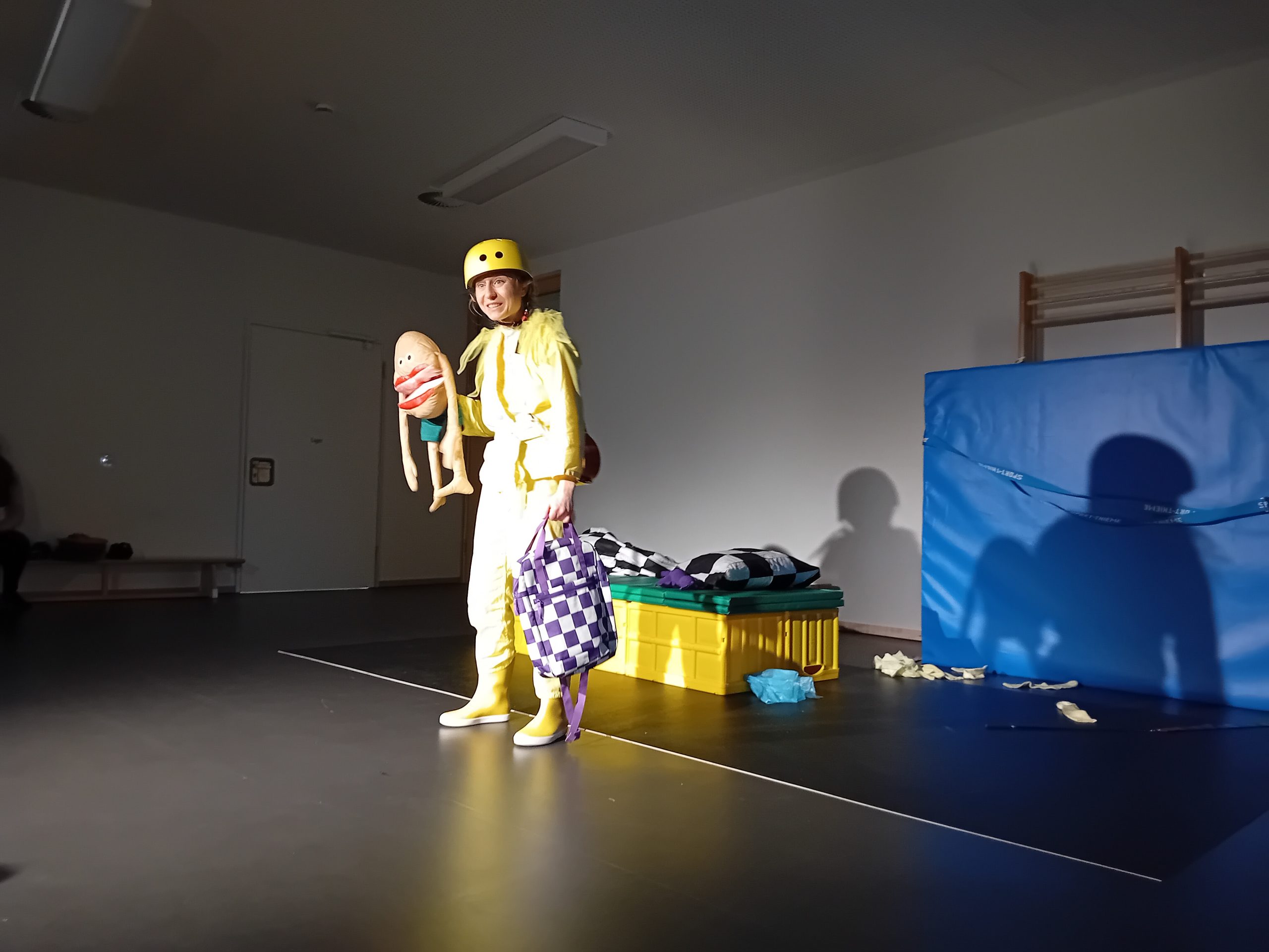 Theaterszene: Frau mit Fahrradhelm und Handpuppe