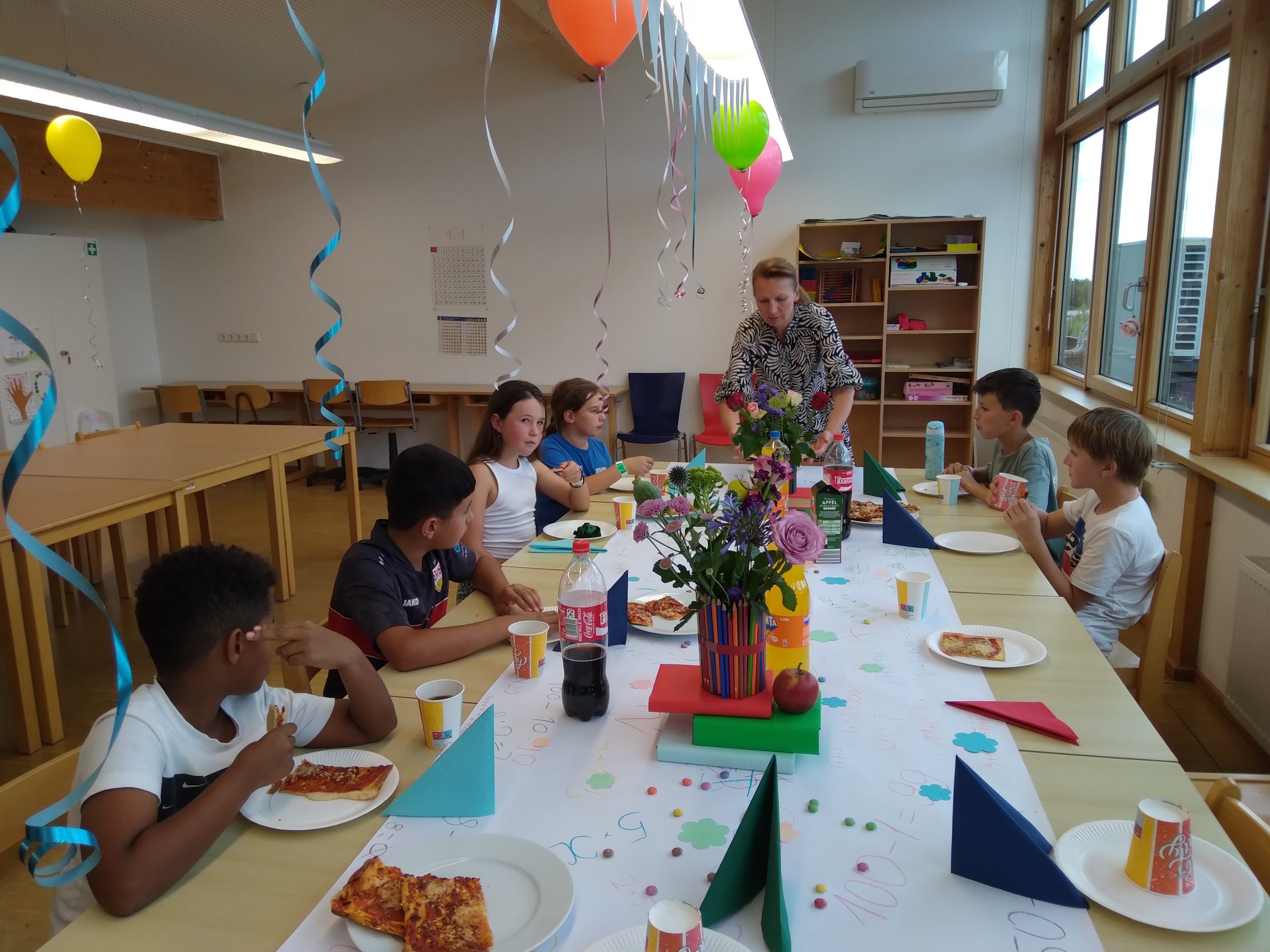 Kinder sitzen an gedecktem Tisch