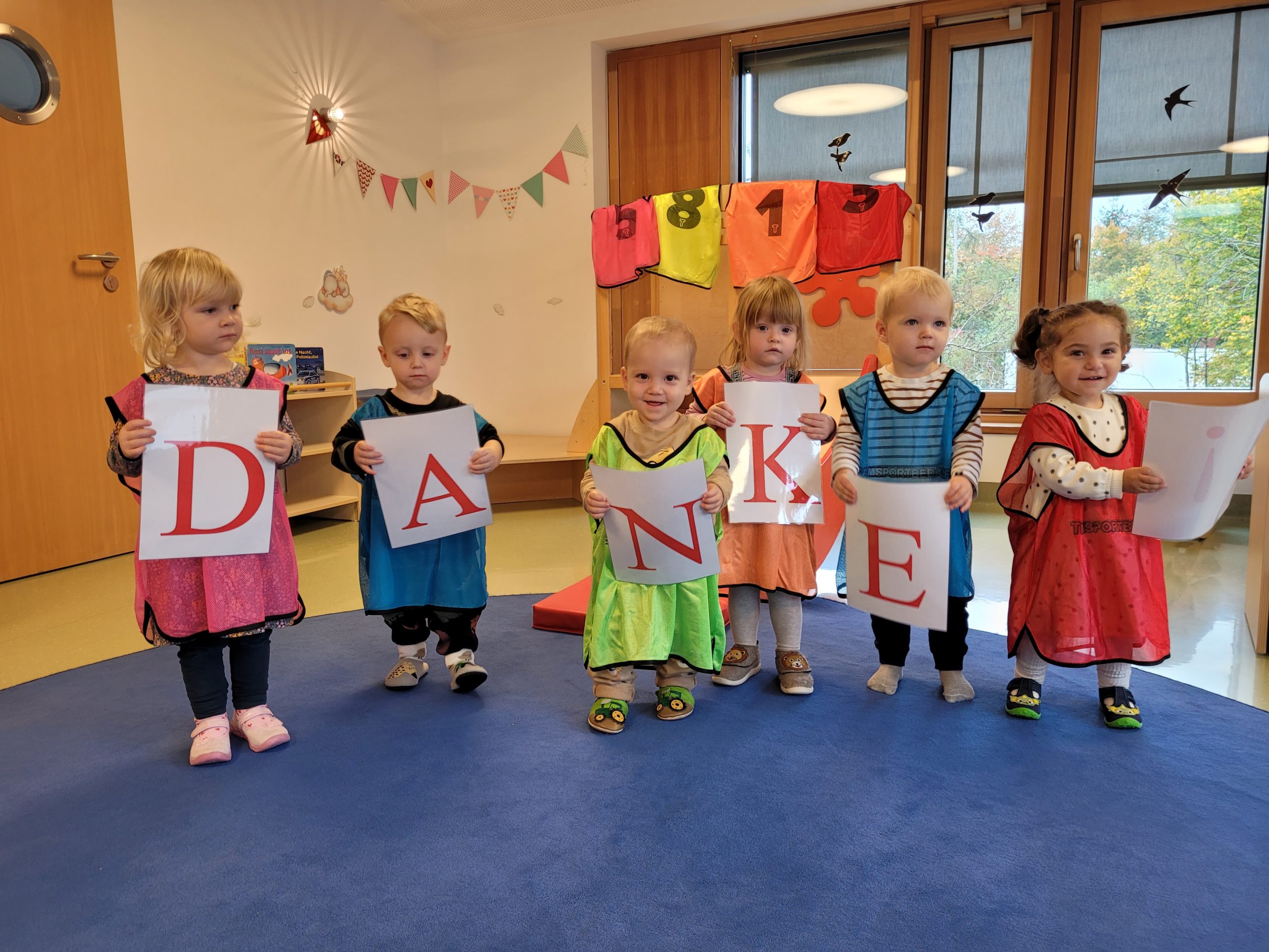 Kinder halten die Buchstaben des Wortes "DANKE"
