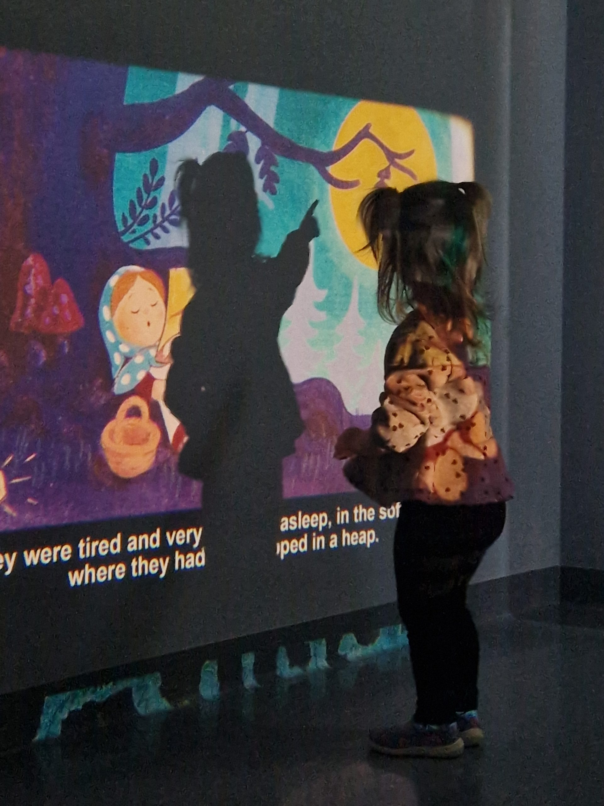 ein Mädchen vor Leinwand mit Schatten darauf