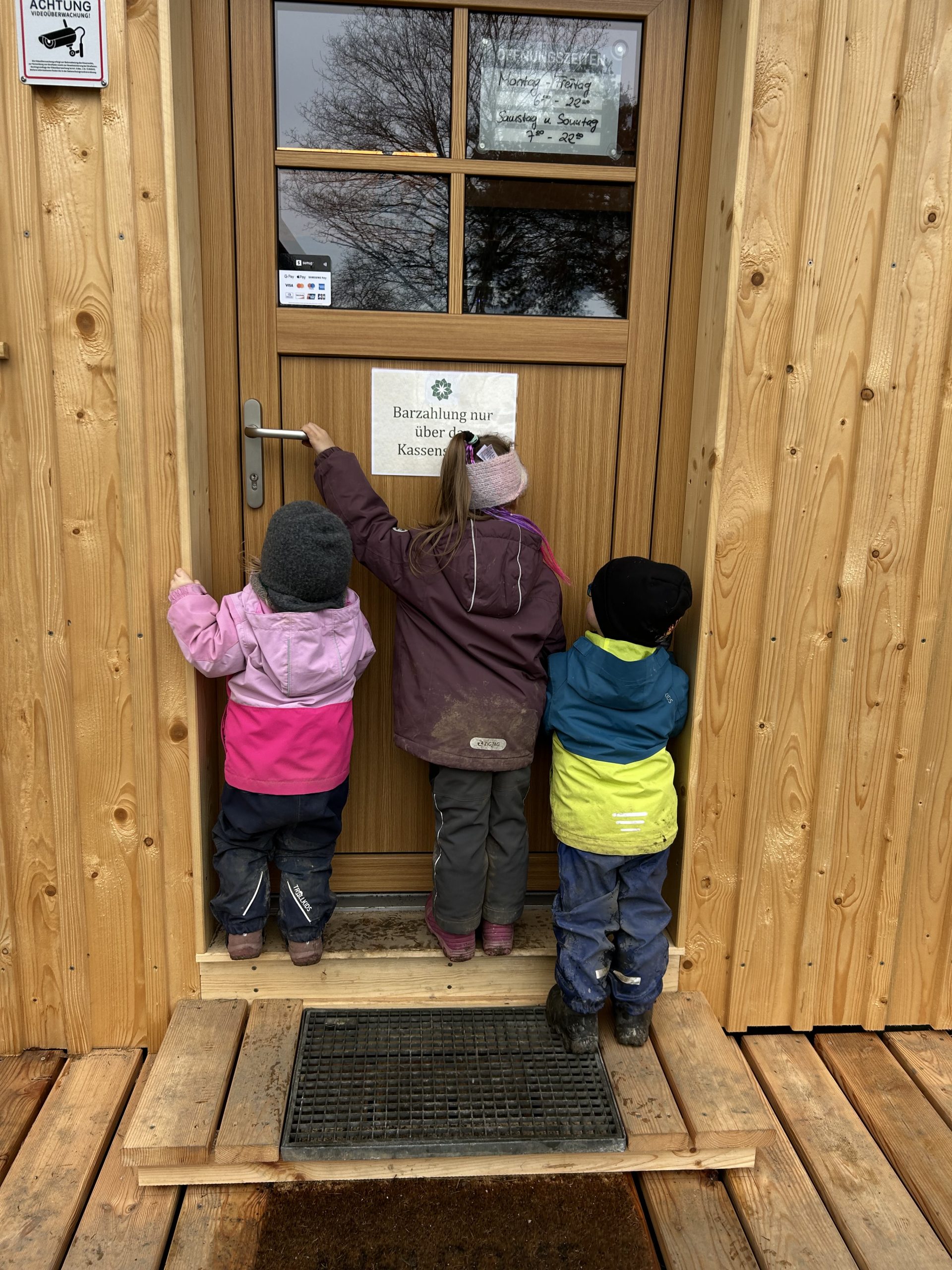 Kinder vor der Tür zum Hofladen