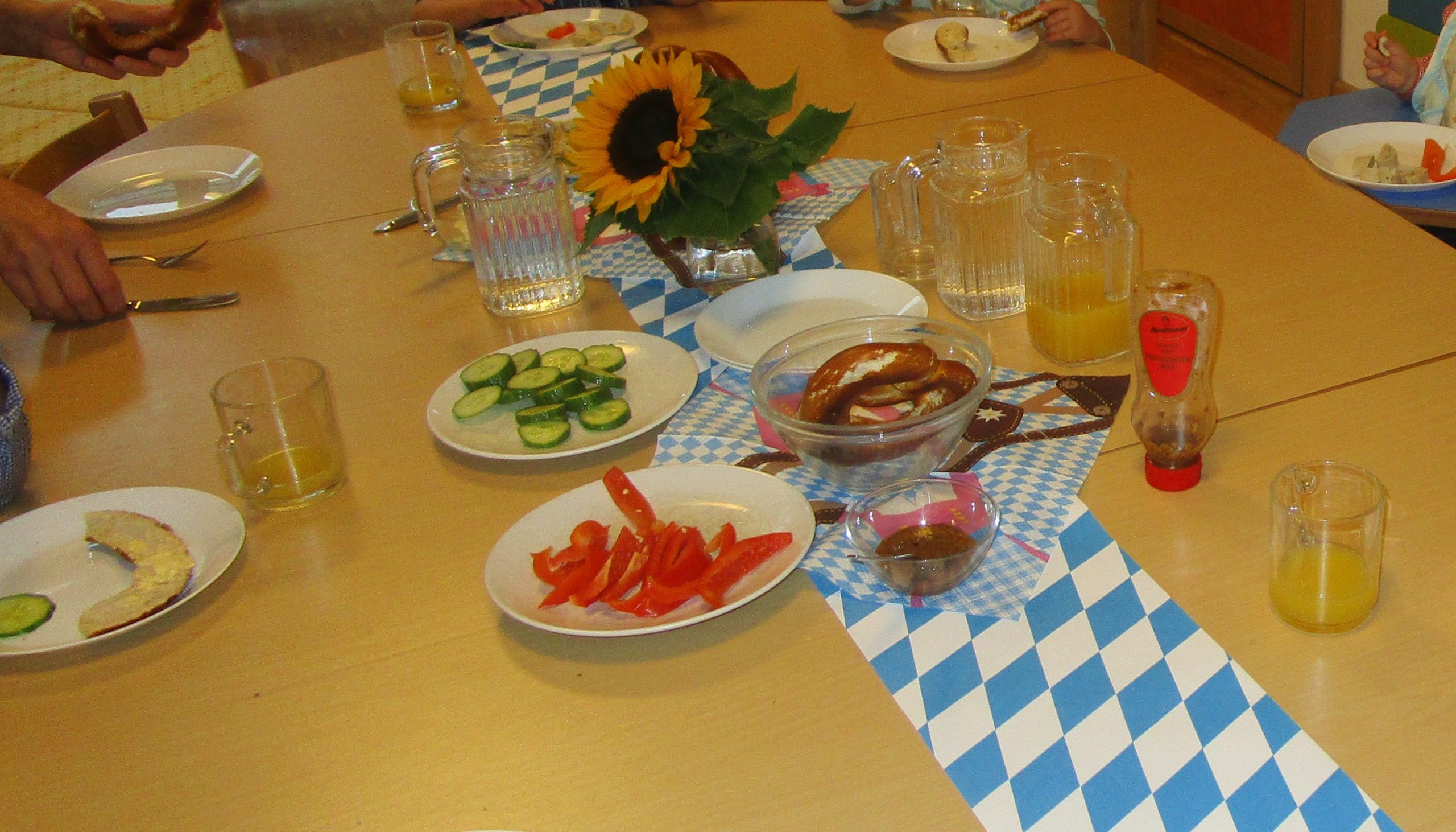 Gedeckter Tisch mit Brezen und Gemüse