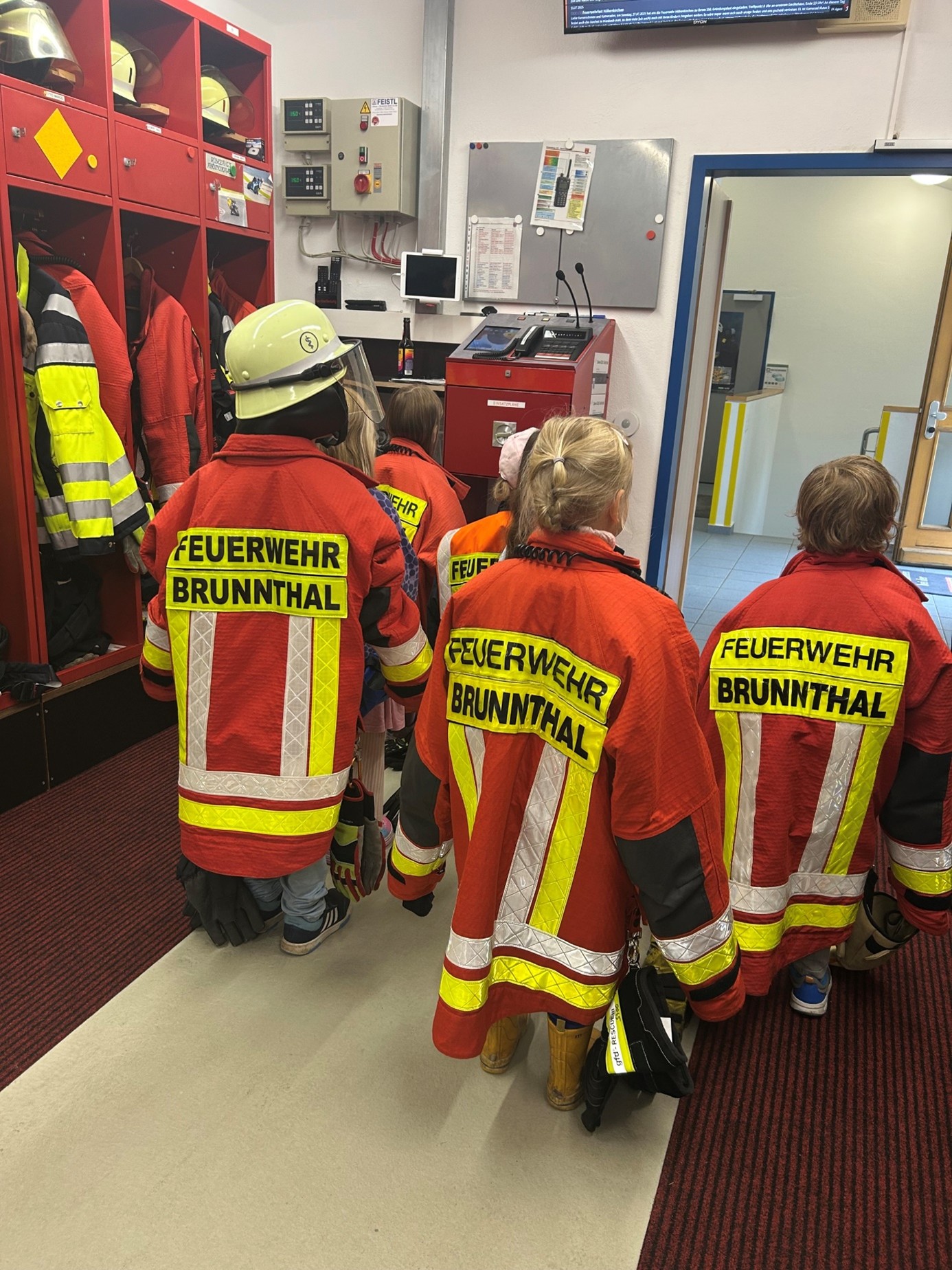 Kinder mit Feuerwehr-Kleidung von hinten