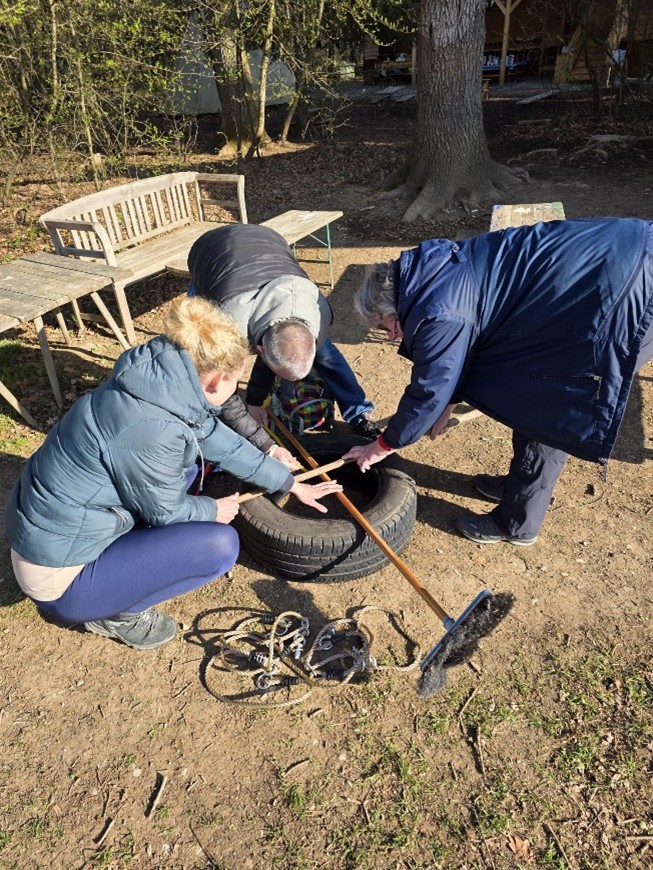 Erwachsene basteln etwas mit einem Autoreifen