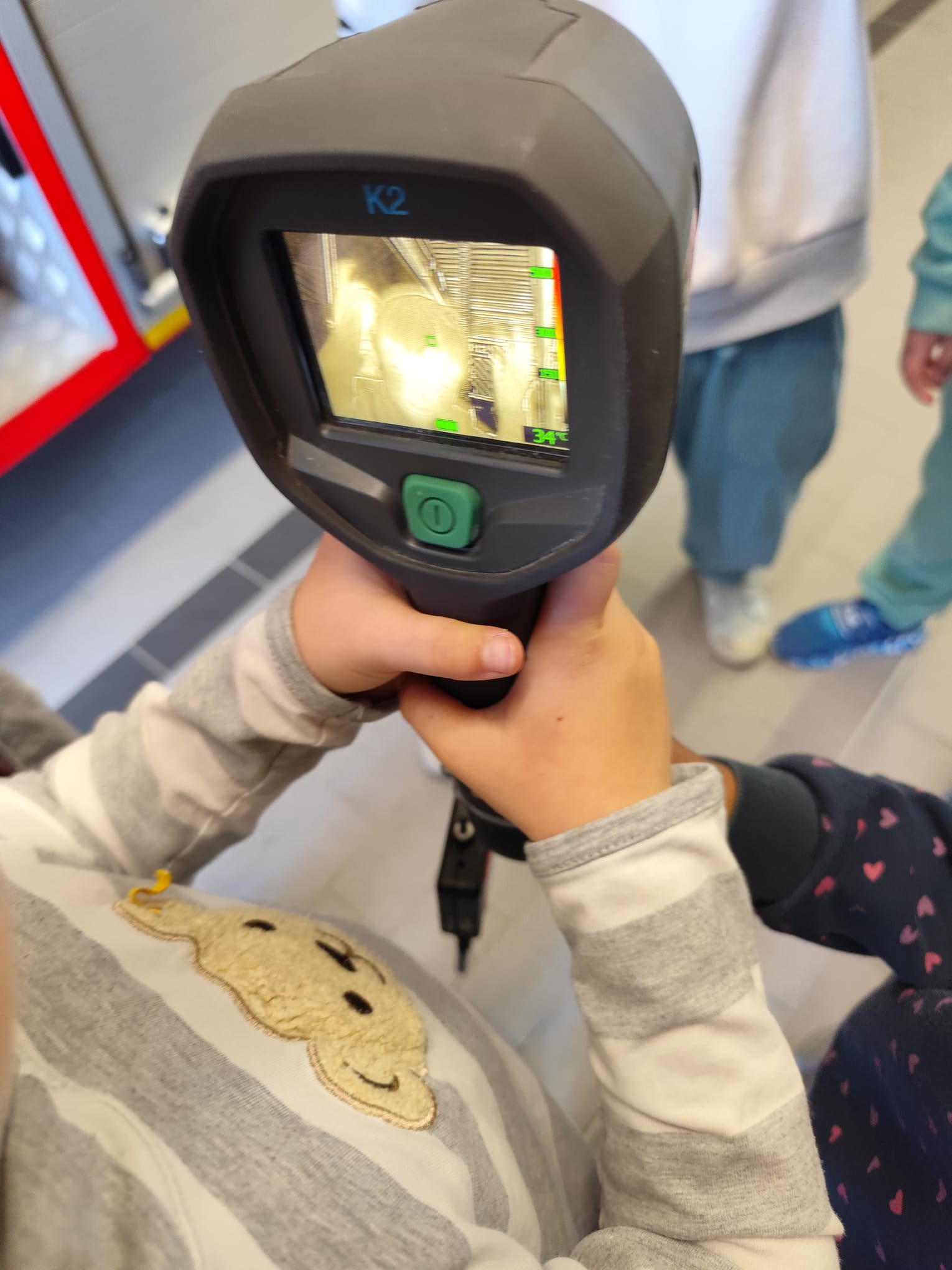 Kind hält Wärmebildkamera