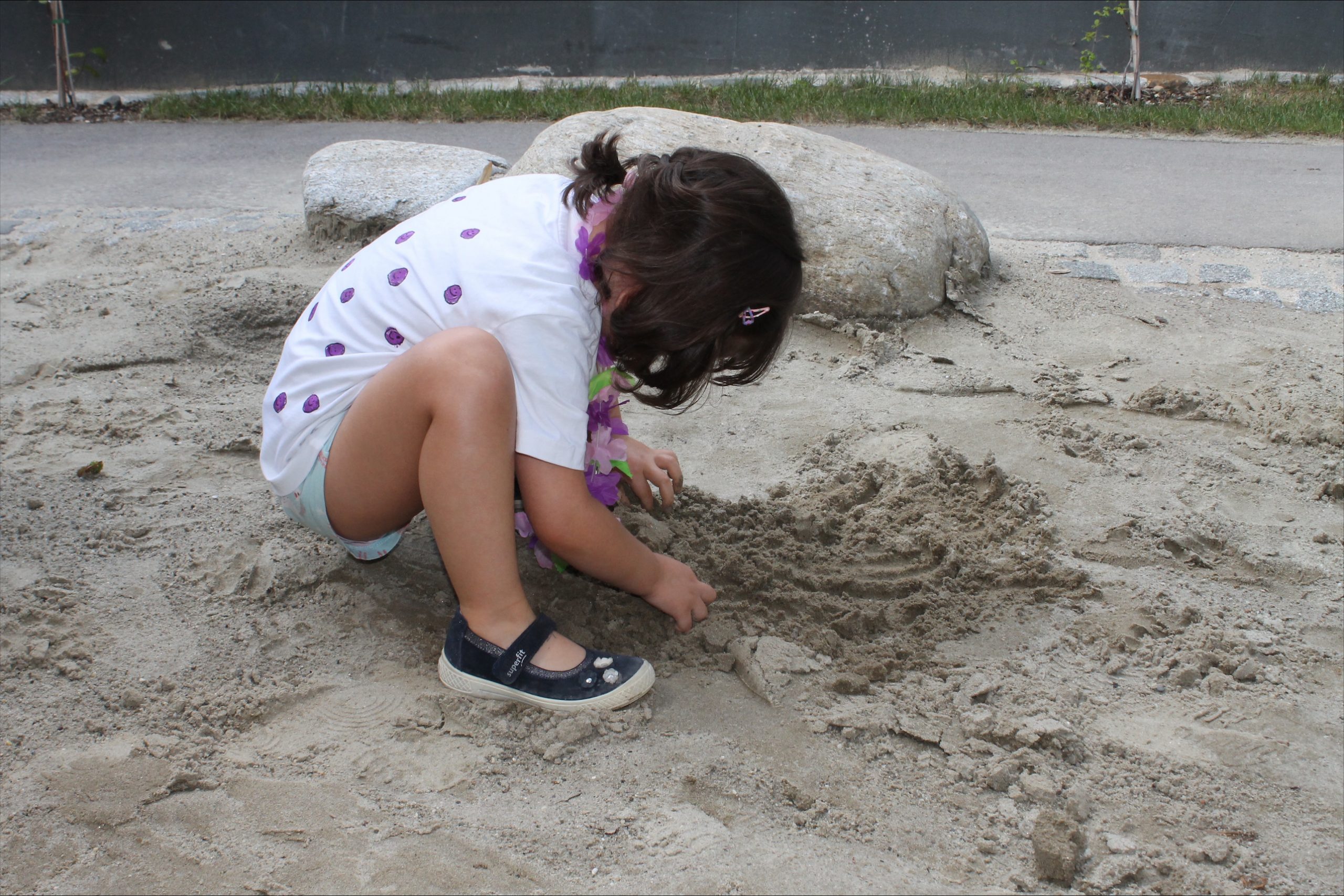 Kind spielt im Sand