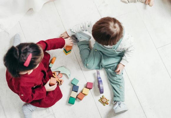 Kinder spielen mit Bauklötzen und Holztieren
