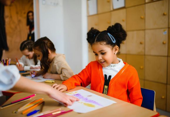 Mädchen bekommt etwas auf ihrem Blatt gezeigt
