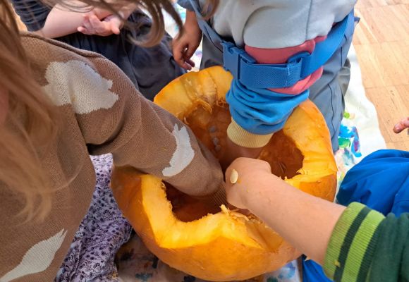 Kinder matschen in Kürbis herum