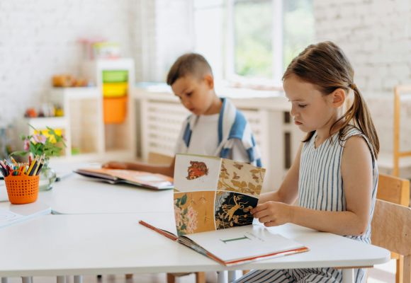 Zwei Kinder blättern in Büchern