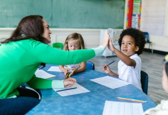 Lehrerin macht High-Five mit einem Schüler