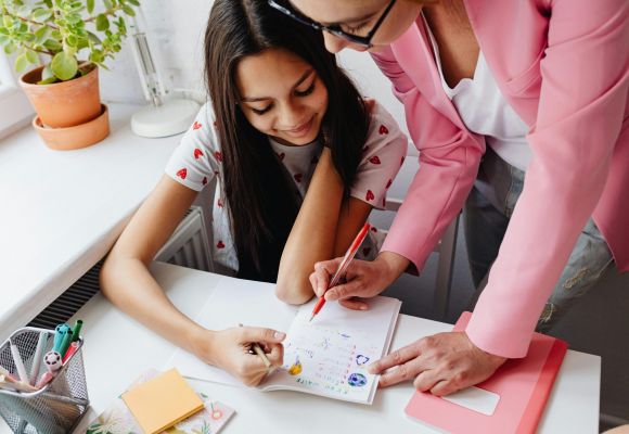 Betreuerin mit Kindern am Tisch